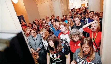  ?? [PHOTO BY NATE BILLINGS, THE OKLAHOMAN] ?? Teachers, students and supporters of increased education funding watch a closed-circuit feed of the House of Representa­tives on Wednesday outside the entrance to the House chamber on the fourth floor of the state Capitol during the third day of a...