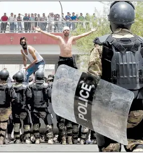  ?? AP ?? Iraqi riot police prevent protesters from storming the provincial council building during a demonstrat­ion Sunday in Basra.