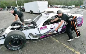  ?? TIM MARTIN/THE DAY ?? Jacob Perry, right, 15, of Pawcatuck, in the pit area with his father, Dennis Perry, as they work on their SK Modified division car at the New London-Waterford Speedbowl.