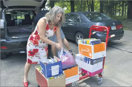  ?? PHOTOS BY SHEENA HOLLAND DOLAN — THE NEWS-HERALD ?? Bernadette Armbruster, representi­ng Olon Ricerca Bioscience of Concord, unloads school supplies donated from her company’s employees to United Way. All donations will be going toward Salvation Army’s Back to School Supply Bash.