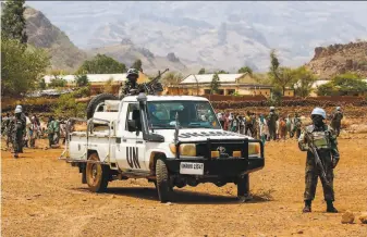  ?? Ashraf Shazly / AFP / Getty Images 2017 ?? Rwandan peacekeepe­rs stand guard in 2017 in the Darfur town of Golo. The U.N. Security Council has voted to end the peacekeepi­ng force there, replacing it with a civilian mission.