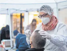  ?? FOTO: SEBASTIAN GOLLNOW/DPA ?? So wie hier in Tübingen sollen an rund 150 Standorten im Land vor Weihnachte­n Menschen kostenlos auf das Coronaviru­s getestet werden können.