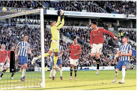  ?? AP ?? United in misery: Brighton and Hove Albion goalkeeper Robert Sanchez collects the ball in front of Manchester United's Cristiano Ronaldo during the English Premier League match at the AMEX Stadium, Brighton. Man United suffered a 4-0 humiliatio­n at the hands of Brighton and Hove Albion.