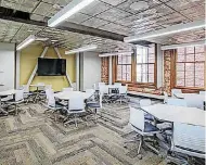  ??  ?? This classroom features replica tin ceiling tiles and exposed lateral bracing used to hang the television screen.