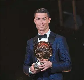  ??  ?? Avec son cinquième Ballon d’or, Cristiano Ronaldo égale Lionel Messi.