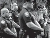  ?? JOHN MINCHILLO/AP ?? People and police gather for a vigil in 2019 in Bellbrook, Ohio, after a mass shooting in Dayton left nine people dead.