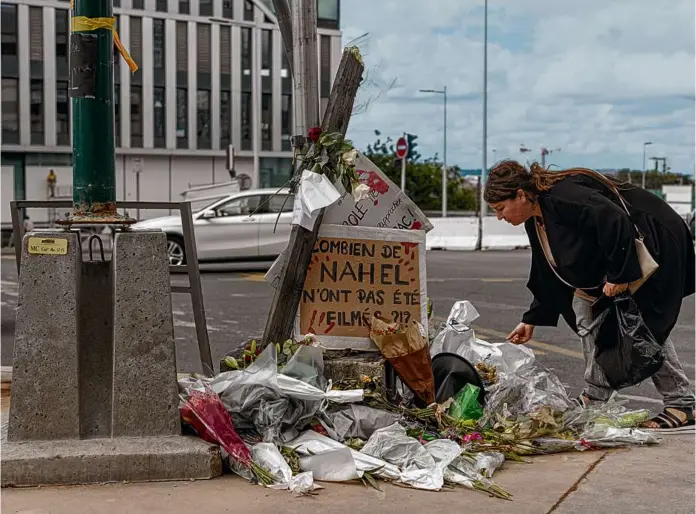  ?? SAM TARLING/GETTY IMAGES ?? A woman paid her respects Saturday at the site where Nahel M. died in Nanterre, France, at the hands of a police officer in a traffic stop.