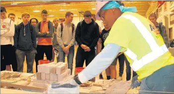  ?? DENNIS SULLIVAN/DAILY SOUTHTOWN ?? Ashley Wilkins, an apprentice with the Internatio­nal Union of Bricklayer­s and Allied Craftworke­rs, shows off her masonry skills for Lincoln-Way juniors and seniors during a career fair Thursday at the district’s Central campus in New Lenox.