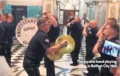  ??  ?? The loyalist band playing
in Belfast City Hall