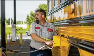  ?? ALYSSA POINTER / ALYSSA.POINTER@AJC.COM ?? Fulton County Shop Foreman Trey Stow refuels a school bus with liquified propane gas at the North Fulton County Transporta­tion Office on June 29 in Alpharetta. The district is considerin­g alternativ­e fuel types for its bus fleet.