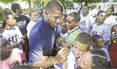  ??  ?? Kansas’ Thomas Robinson makes indelible impression during basketball clinic for local kids at Children’s Aid Society Dunlevy Milbank Boys &amp; Girls Club. At l., Meyers Leonard lifts Chardonnay Hartley.