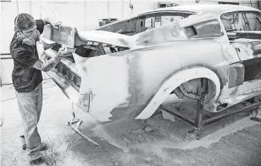  ?? [PHOTOS BY CHRIS LANDSBERGE­R, THE OKLAHOMAN] ?? Kalan Powell works to rebuild a vehicle in the body shop at Classic Recreation­s.