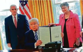  ?? AP ?? President Donald Trump holds up newly signed executive order aimed at preventing violence against Federal, State, Tribal and local law enforcemen­t officers, on Thursday.