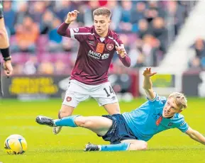  ?? ?? Dundee’s Max Anderson slides in on Hearts Cammy Devlin