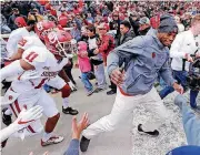  ?? [PHOTO BY STEVE SISNEY, THE OKLAHOMAN] ?? Former Oklahoma and NFL star Adrian Peterson leads his team on to the field for Saturday’s Red-White spring game at Gaylord Family — Oklahoma Memorial Stadium. Peterson was an honorary coach for the White team.