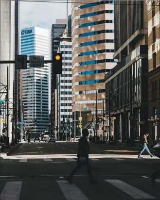  ?? BENJAMIN RASMUSSEN / THE NEW YORK TIMES ?? Pedestrian­s walk the streets of downtown Denver on March 28. Suburban homeowners who have profited from the urban exodus during the pandemic are leaving small-town life behind to find out what they have been missing.