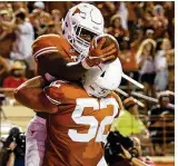  ?? NICK WAGNER / AMERICAN-STATESMAN ?? UT running back Tre Watson (top) celebrates his touchdown with offensive lineman Samuel Cosmi (52) in Saturday’s win against Tulsa. Cosmi is among 10 members of UT’s 2017 class who have started at least one game.