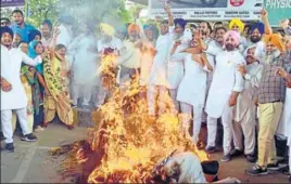  ?? SAMEER SEHGAL/HT ?? ■ SAD workers burning the effigies of Congress president Rahul Gandhi, Punjab chief minister Captain Amarinder Singh and Punjab Congress Chief Sunil Jakhar in protest against Justice Ranjit Singh (retd) Commission report on sacrilege incidents, in Amritsar on Saturday.