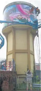  ?? PICTURES: MARK LEWIS ?? Above and right, workers install the mural on the water tower