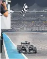  ?? Getty Images. Pictures: ?? Top: World champion Lewis Hamilton celebrates on the podium in Abu Dhabi. Above: Hamilton takes the chequered flag as he wins his 11th race of the season.