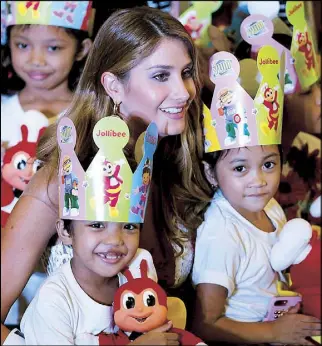  ?? MIGUEL DE GUZMAN ?? Miss Venezuela Mariam Habach poses with orphaned children from the Concordia Children’s Services as Miss Universe candidates shared a meal with the kids at a Jollibee branch in Pasay City yesterday.