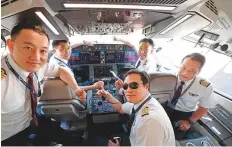  ?? AFP ?? Pilots take photos before the first commercial flight of China’s first domestical­ly produced passenger jet C919 yesterday.