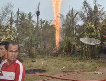  ?? (AP) ?? An oil well burns in Pasi Putih village in eastern Aceh, Indonesia, Wednesday, April 25, 2018. The newly drilled, unregulate­d oil well caught fire as people were trying to collect the oil early Wednesday, burning to death a number of people and...