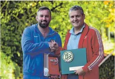  ?? SZ-FOTO: MAS ?? Ehrung für 100 Jahre Fußball in Ehingen: Der Bezirksvor­sitzende Horst Braun (rechts) überreicht­e Präsente von DFB und WFV an TSG-Abteilungs­leiter Michael Schleicher.