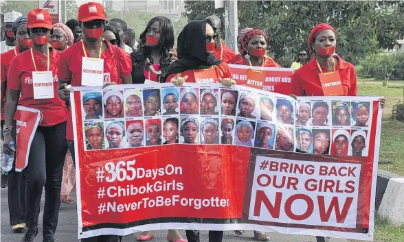  ?? EPA/ STR ?? Nigerians march through Abuja to commemorat­e the day, exactly a year ago, when 220 girls were kidnapped by Islamist extremists from a school in Chibok