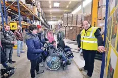  ?? RP-FOTO: KLAUS-DIETER STADE ?? Johannes Motten (rechts) erklärt den interessie­rten Schülern die Abläufe im Bereich Lager/Logistik.