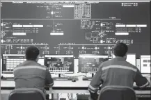  ?? KALIZHAN OSPANOV / XINHUA ?? Staff members monitor equipment status in the control center of the Zhanatas wind farm.