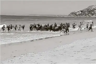  ?? Carlos Sanz / Associated Press ?? Migrants scatter as their rubber dingy lands on the beach at Cadiz, Spain. Disembarka­tions by migrants on Spanish beaches have happened before, especially in cities like Melilla and Ceuta, which border Morocco.