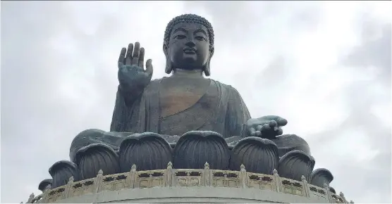  ?? LISA MONFORTON/ CALGARY HERALD ?? Devout Buddhists come from all over the world to visit the 34-metre bronze Big Buddha, one of the largest in the world. Set in a beautiful green valley on Lantau Island, it an easy day trip from Hong Kong and the endless valley, mountain and sea views...