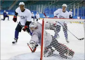  ?? THE ASSOCIATED PRESS ?? United States goalie Brandon Maxwell reaches for a puck as Jordan Greenway, left, and Ryan Donato watch during practice ahead of the 2018Winter Olympics in Gangneung, South Korea, Friday, Feb. 9, 2018.