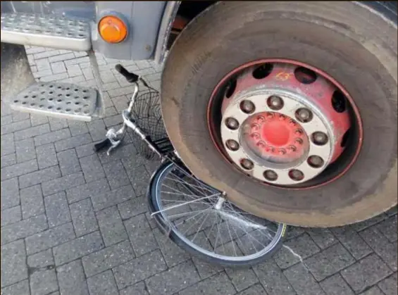  ?? FOTO THEO VAN VELTHOVEN ?? De fiets van Magda ligt pal onder het wiel van de vrachtwage­n. “Ik heb écht veel geluk gehad.”