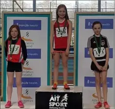  ??  ?? Meabh O’Connor (3rd) and Enya Silkena (1st) Dundalk St Gerards AC on the podium after the U12 girls long jump at the Leinster indoor championsh­ips in Athlone.