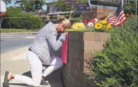  ?? Mark Wilson / Getty Images ?? Lynne Griffin pays her respects at a makeshift memorial Friday near the Capital Gazette, where five people were shot and killed by a gunman on Thursday in Annapolis, Md. Griffin was a journalism student under John McNamara, who was one of the people...