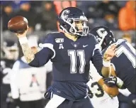  ?? Stephen Dunn / Associated Press ?? UConn quarterbac­k Jack Zergiotis (11) looks for a receiver against Navy last week.