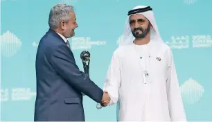  ?? — Photos by Dhes Handumon ?? Sheikh Mohammed congratula­tes Dr Ferozuddin Feroz for winning the Best Minister Award at the summit in Dubai on Sunday.