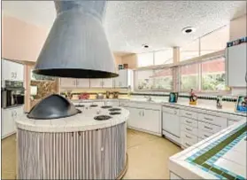  ??  ?? THE CIRCULAR motif is seen in the kitchen island and hood.