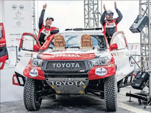  ??  ?? Marc Coma y Fernando Alonso celebran, subidos al Toyota con el que correrán el Dakar, el tercer puesto en el Al-Ula Neom Rally de Arabia Saudí.
