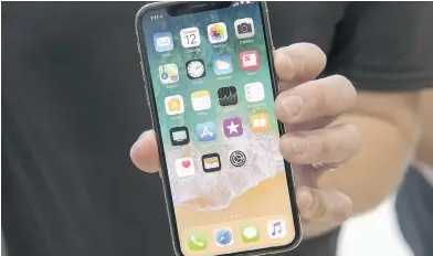  ?? DAVID PAUL MORRIS / BLOOMBERG ?? An attendee displays an Apple Inc. iPhone X at the Steve Jobs Theater in Cupertino on Tuesday.