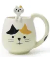  ??  ?? Cats are a popular motif in Asian tableware, symbolizin­g good luck. This mug comes with its own little kitten spoon.