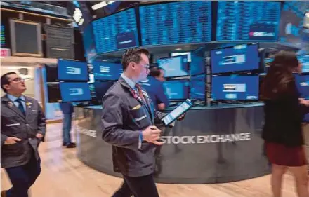  ?? AFP PIC ?? Traders at the floor of the New York stock exchange last week. Economists estimate an internatio­nal wealth tax could raise US$200 billion annually.