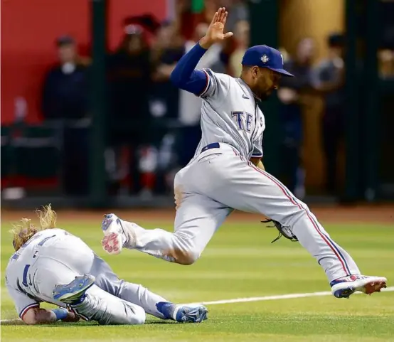  ?? CHRISTIAN PETERSEN/GETTY IMAGES ?? Marcus Semien (right) had a scary collision with Rangers teammate Travis Jankowski at the end of the seventh inning .