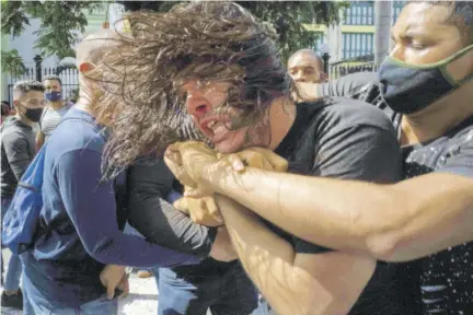  ??  ?? Plaincloth­es police detain an anti-government protester during a protest in Havana, Cuba, Sunday,