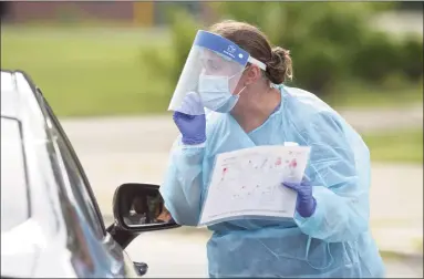  ?? H John Voorhees III / Hearst Connecticu­t Media file photo ?? Heidi Bettcher, a public health nurse, uses an illustrate­d pamphlet to explain how to do a self-administer­ed COVID test during the first day of the New Milford Health Department’s COVID-19 drive-thru testing site at John Pettibone Community Center on Aug. 11 in New Milford.