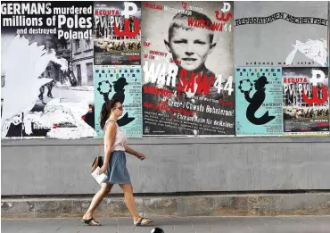  ?? Foto: dpa/Czarek Sokolowski ?? 2017 kleben Plakate in Warschau, die zu Reparation­en auffordern.