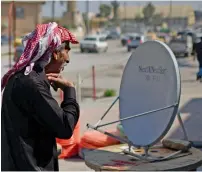  ?? AFP ?? An Iraqi man looks at a satellite dish at a market in Mosul. —