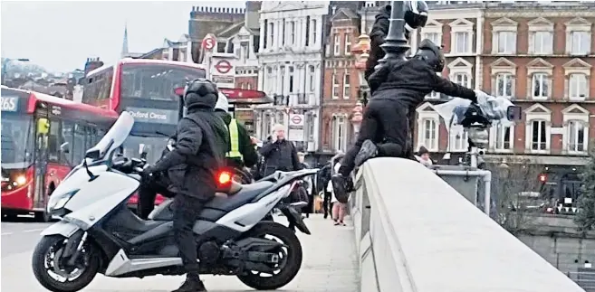  ??  ?? Brazen thieves on a motorcycle were recorded holding up rush-hour traffic on Putney Bridge while attempting to steal a camera secured for coverage of the Boat Race